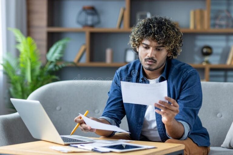 henkilo tarkastelee talouspapereita kotona