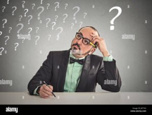 ihminen pohtimassa kysymyksia poydan aaressa