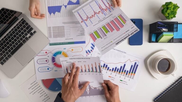 kuvassa ihmisia analysoimassa talouskaavioita