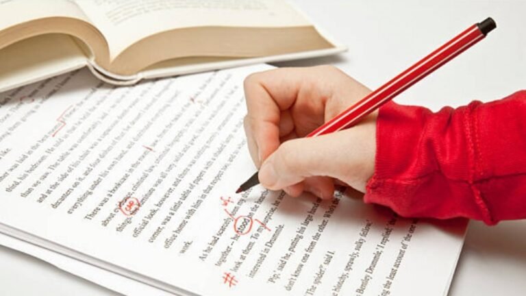 kynalla kirjoittava henkilo ja kielioppikirja