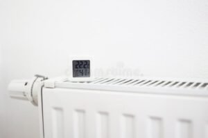 lammittava patteri huoneessa lampotilamittarin kanssa