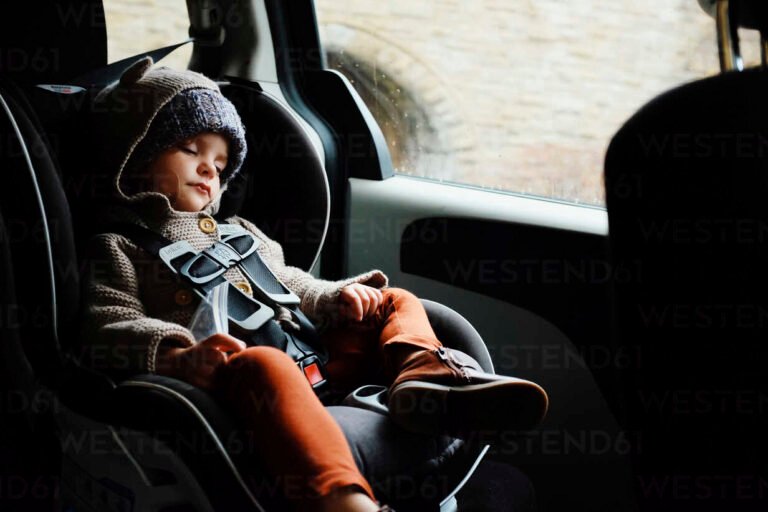 lapsi istuinkorokkeella auton takapenkilla