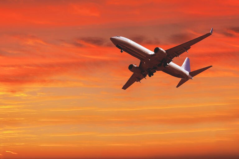 lentokone taivaalla auringonlaskun aikaan