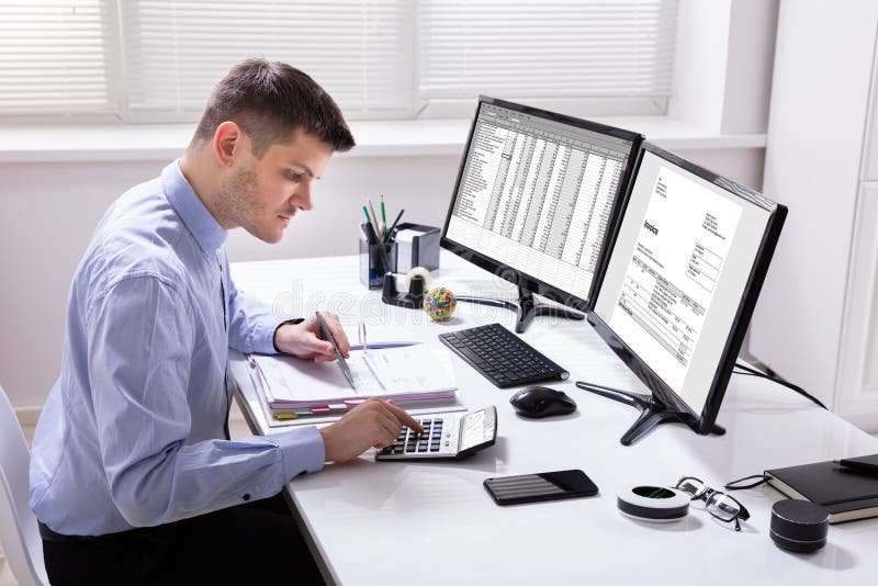 liikemies tarkastaa laskuja toimistoymparistossa