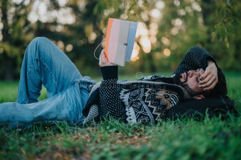 mietiskeleva mies lukemassa kirjoja luonnossa