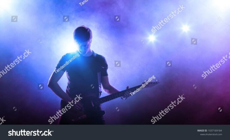 nuori mies soittaa kitaraa lavalla
