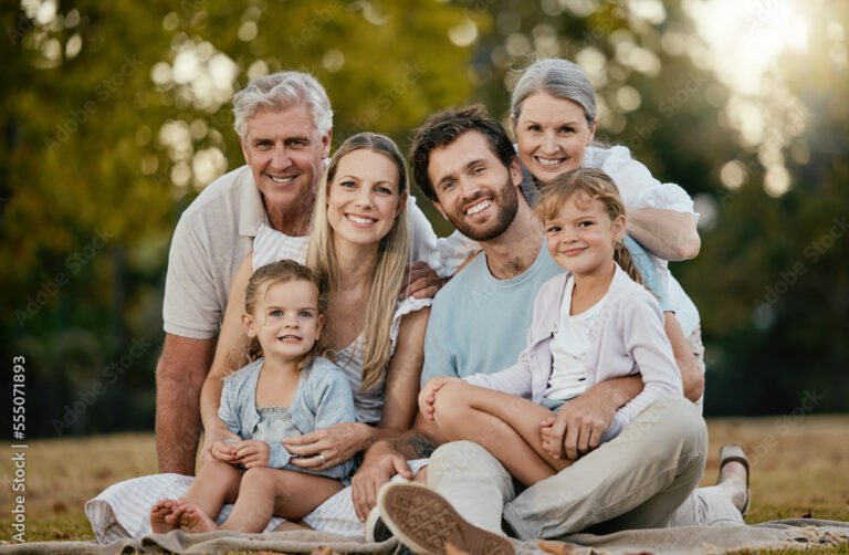 perhe hymyilemassa yhdessa luonnossa