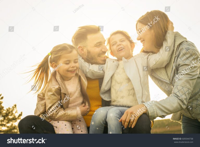 perhe ulkona halaamassa toisiaan iloisesti