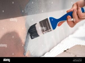 puhdas ulkoseina ja maalipensseli lahikuvassa