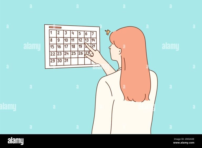 raskaana oleva nainen tarkasti kalenteria katsomassa