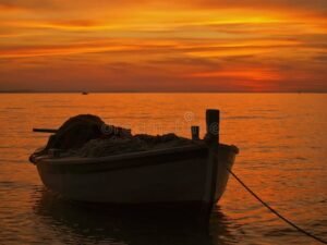 vene lahestyy sujuvasti puulaituria auringonlaskussa