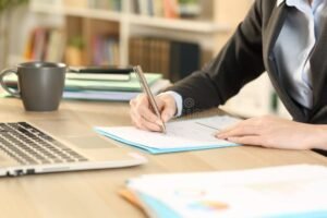 yrittaja tayttaa lomakkeen kotitoimistossaan